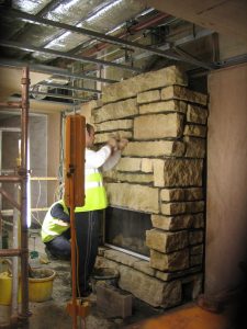 Installation-of-a-Contemporary-Fireplace-in-Rock-Faced-Cottae-Stone